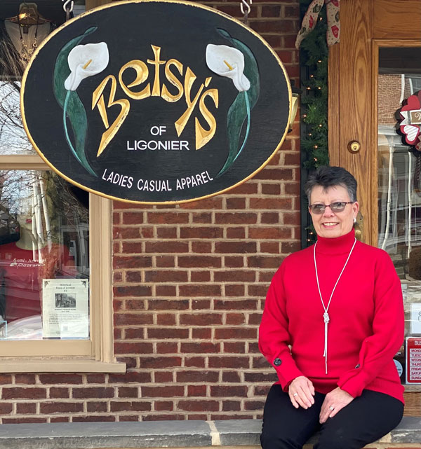 A person sitting on a bench in front of a sign