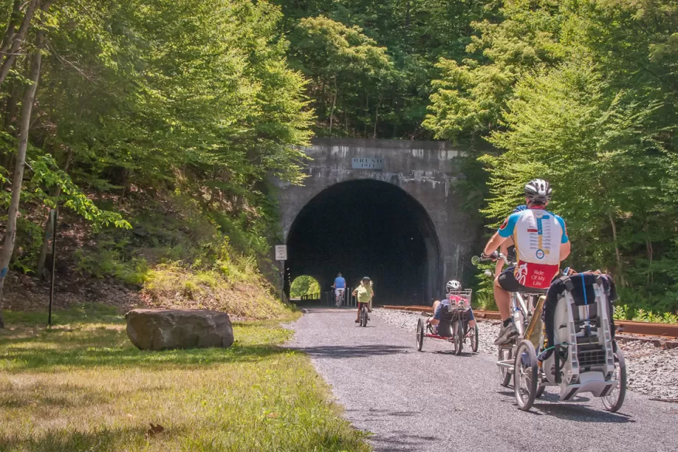 family biking on biking trail along side rail tracks